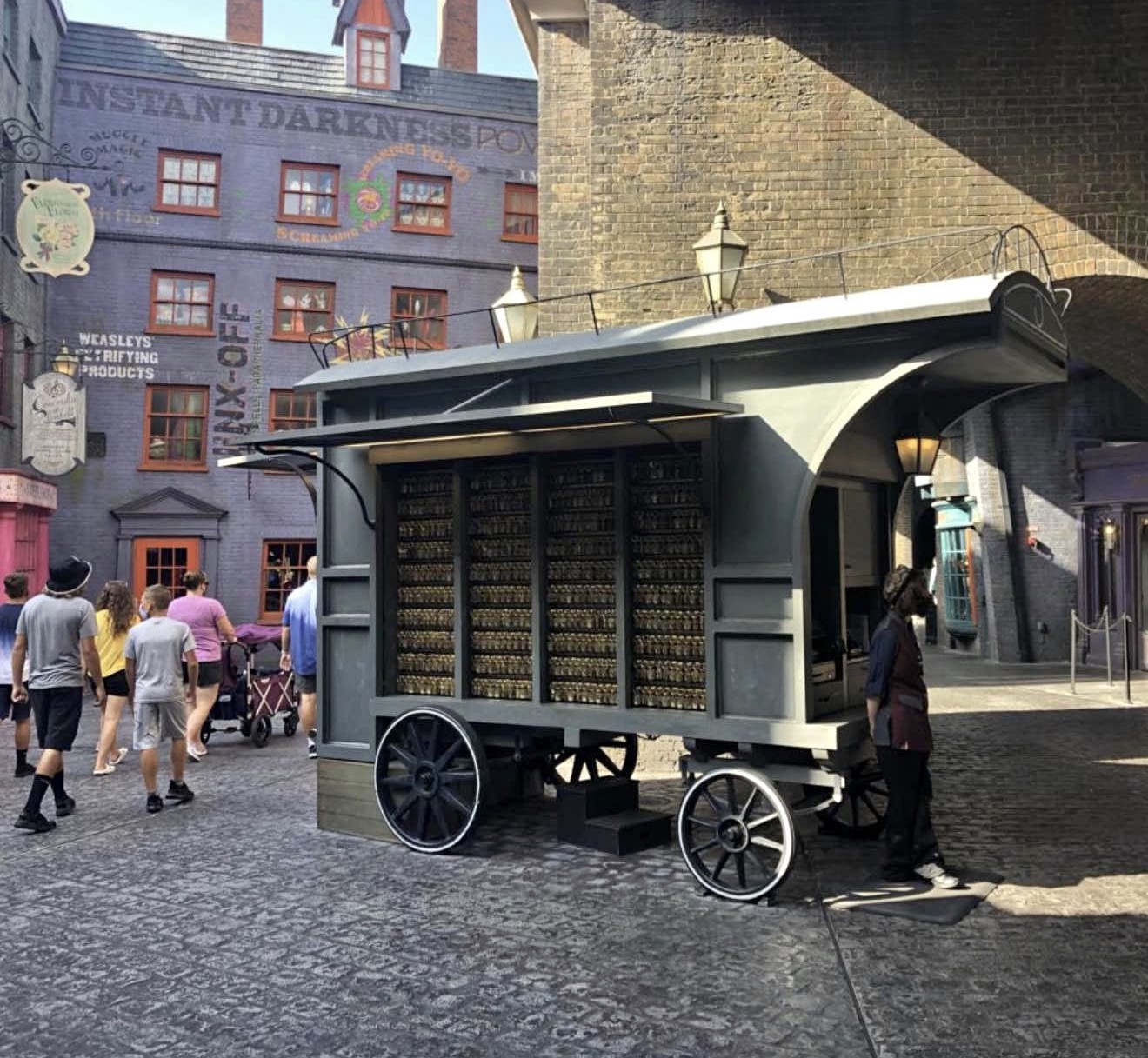 Harry Potter wagon for sale shown in Diagon Alley at Universal Studios Florida, with shelves of bottles in front of Weasleys' Wizard Wheezes